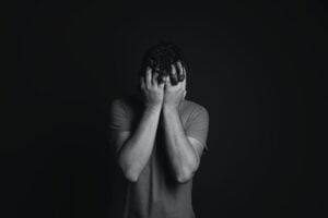 mental raiva depressao gray scale photo of man covering face with his hands