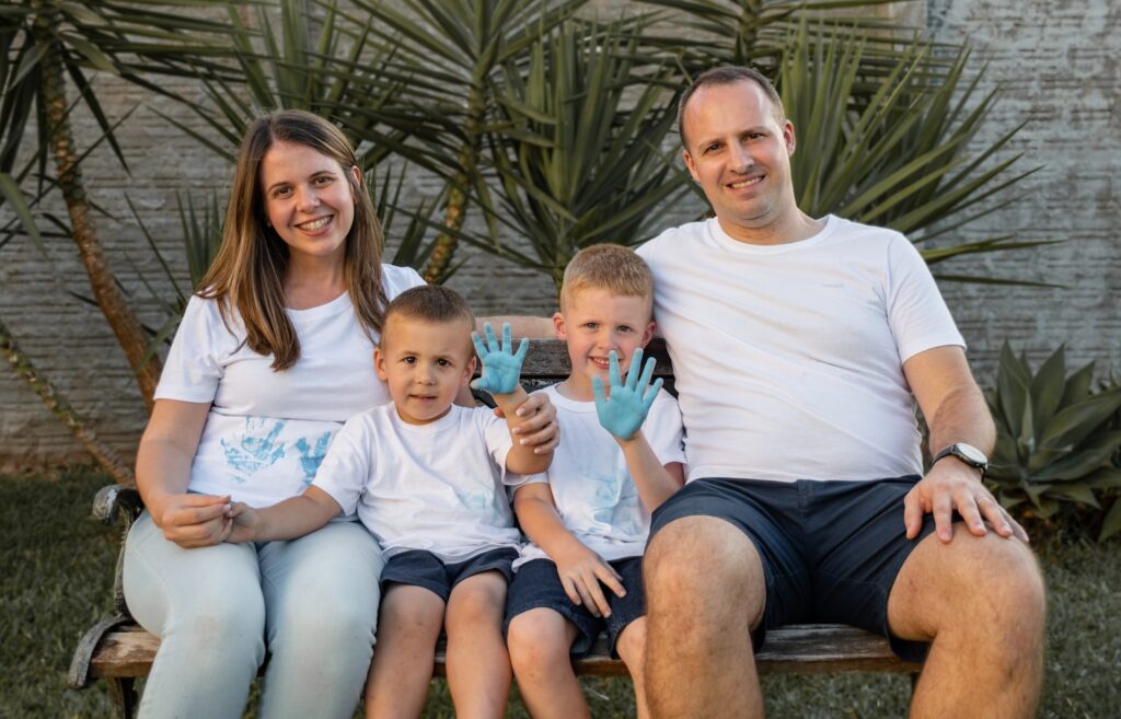 Porque fazer um seguro? a family sitting on a bench posing for a picture